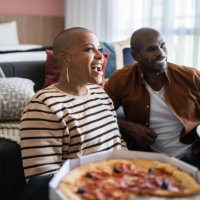 mature couple eating pizza and watching tv at home - junk food stock pictures, royalty-free photos & images