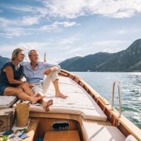 mature couple relax on sailboat moving through lake lugano - travel stock pictures, royalty-free photos & images
