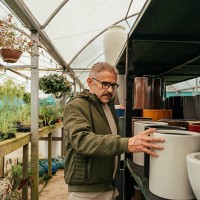 mature man choosing flower pots in flower shop - garden decoration stock pictures, royalty-free photos & images