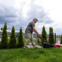 mature man cutting grass in his backyard - garden decoration stock pictures, royalty-free photos & images