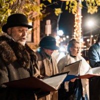 mature people singing christmas carols outdoors at night - concert stock pictures, royalty-free photos & images