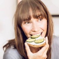 mature woman eating healthy cucumber bread - food photos et images de collection