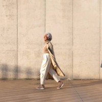 mature woman in trench coat walking on footpath - fashion stock pictures, royalty-free photos & images