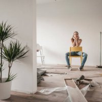 mature woman moving house, sitting on chair - home decoration stockfoto's en -beelden