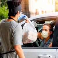 mature woman picking her restaurant food from her car at a pick up curve - junk food stock pictures, royalty-free photos & images