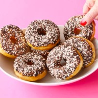 mature woman taking a doughnut - junk food stock pictures, royalty-free photos & images
