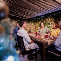 mature woman talking with her family at christmas dinner - garden decoration stock pictures, royalty-free photos & images