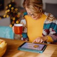 mature woman using digital tablet for online christmas shopping - home decoration stock pictures, royalty-free photos & images
