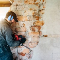 mature worker demolishing wall with drill at house - home decoration stock pictures, royalty-free photos & images