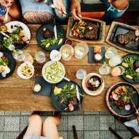 medium overhead shot of families sharing dinner at outdoor restaurant - food stock pictures, royalty-free photos & images