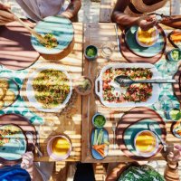 medium overhead shot of friends sharing lunch at outdoor table - food stock pictures, royalty-free photos & images