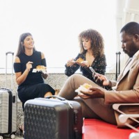 medium shot of friends waiting for flight in departure area of airport - food stock pictures, royalty-free photos & images