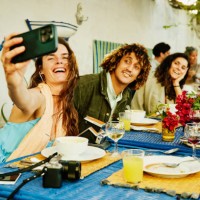 medium shot woman taking selfie of friends and family at restaurant - home decoration stock pictures, royalty-free photos & images