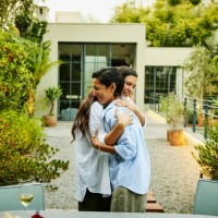 medium wide shot smiling friends embracing during rooftop garden party - garden decoration photos et images de collection