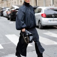 Mehrnaz Ansari wears black bomber jacket, black long skirt, black Chanel bag, black boots, black Chanel sunglasses, outside Stella McCartney, during...