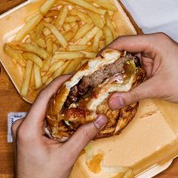 men eating hamburger and fries, phone with picture - junk food stock pictures, royalty-free photos & images
