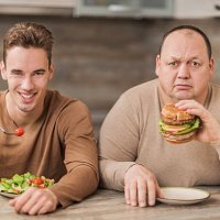 men eating in the kitchen and looking at camera. - junk food stock pictures, royalty-free photos & images