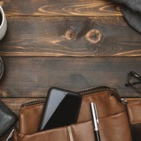 men's satchel bags, mobile phone and male personal belongings on rustic wood - fashion stock pictures, royalty-free photos & images