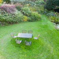 metal table and chairs on lawn; veddw house garden, october, autumn. image taken from drone. - garden decoration photos et images de collection