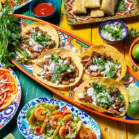 mexican independence day table, food for independencia -chiles en nogada, tacos al pastor, chalupas pozole, tamales, chicken with mole poblano sauce. yellow and green wooden background - food stock pictures, royalty-free phot