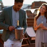 mid adult couple at party on roof terrace holding ice bucket with champagne smiling - garden decoration stock pictures, royalty-free photos & images
