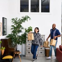 mid adult man and woman bringing takeaway food home - junk food stock pictures, royalty-free photos & images
