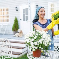 mid adult woman planting flowers in front of a porch - garden decoration stock pictures, royalty-free photos & images
