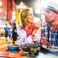 middle-aged man and his companion handsome blond lady in bangkok chinatown - food stock pictures, royalty-free photos & images