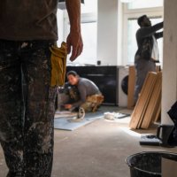 midsection of carpenter carrying plank while coworkers working in kitchen at home - home decoration stock pictures, royalty-free photos & images