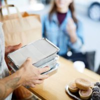 midsection of salesman holding takeaway packaged food for customers at concession stand - junk food stock pictures, royalty-free photos & images