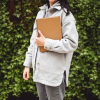 midsection of unrecognizable woman in a coat with a black note pad. - garden decoration stock pictures, royalty-free photos & images