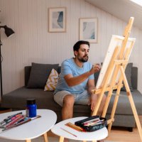 mise au point sélective d’un jeune homme dessinant une image sur un chevalet à la maison - nails art photos et images de collection