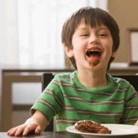 mixed race boy eating cupcake - junk food stock pictures, royalty-free photos & images