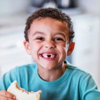 mixed race boy eating peanut butter sandwich - food stock pictures, royalty-free photos & images
