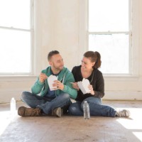 mixed race couple eating takeout on floor of new home - junk food stock pictures, royalty-free photos & images
