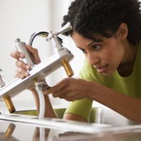 mixed race woman installing faucet - home decoration stock pictures, royalty-free photos & images