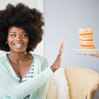 mixed race woman refusing donuts - junk food stock pictures, royalty-free photos & images