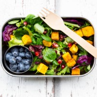 mixed salad with roasted tofu, red cabbage, pomegranate seeds, blueberries and curcuma in lunch box - junk food stock pictures, royalty-free photos & images