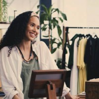 moda, cajera y mujer en la tienda, ventas de pequeñas empresas con sonrisa amistosa, pos y compras. ropa vintage, persona feliz y regístrese en una tienda de segunda mano, trabajadora minorista y gerente de una boutique de lu