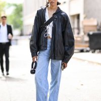 Model Ena Poppe is seen wearing a black jacket, white top, light blue jeans and black shoes outside the Miu Miu show during the Womenswear...