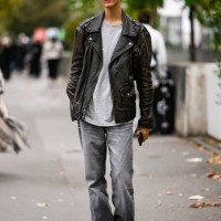 Model is seen wearing a black biker jacket, gray shirt and gray jeans outside the Zimmermann show during Womenswear Spring/Summer 2025 as part of...