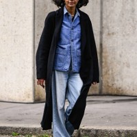 Model is seen wearing a black coat, blue shirt, faded jeans, black shoes and black bag outside the Miu Miu show during the Womenswear Fall/Winter...
