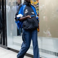 Model is seen wearing a blue and black jacket, blue pant, blue sneakers and brown sunglasses outside the Carolina Herrera show during New York...