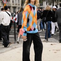 Model is seen wearing a blue and orange sweater and black jeans outside the Chanel show during the Womenswear Spring/Summer 2024 as part of Paris...
