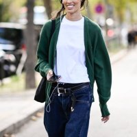 Model is seen wearing a green cardigan, white t-shirt and blue jeans with black bag outside the Miu Miu show during the Womenswear Spring/Summer 2024...