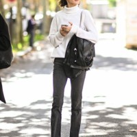 Model is seen wearing a white sweater, black jeans and black coat outside the Miu Miu show during Womenswear Spring/Summer 2025 as part of Paris...