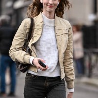 Model Melinda Kiss is seen wearing a tan jacket, white shirt, black and brown faded jeans and brown bag outside the Rokh show during the Womenswear...