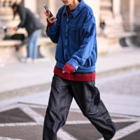 Model Song Ah Woo is seen wearing a blue jacket, red sweater, black pants and Adidas sneakers outside the Louis Vuitton show during Womenswear...