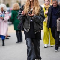 Model wears a black leather bomber jacket , black leather flared pants , Adidas sneakers shoes , outside Chanel, during the Womenswear Fall/Winter...