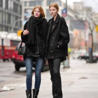 Model wears a black scarf, a black fluffy coat ; a model wears a black oversized jacket with a YSL brooch, outside Brandon Maxwell, during New York...